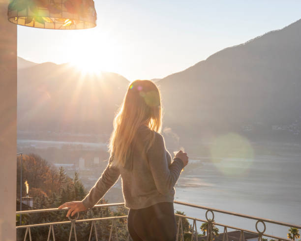 She sips on tea and looks off to distant soaking up some natural sunlight